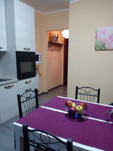 特雷莫西内Appartamento Flora的厨房配有一张桌子,上面放着一碗水果