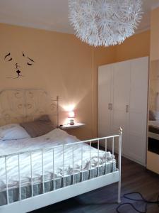 特雷莫西内Appartamento Flora的卧室配有白色的床和吊灯。