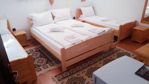 科伦德Hazanéző Panzió的一间设有两张床和两张桌子的房间