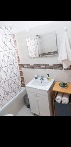 法鲁Reis Turismo的浴室配有盥洗盆、镜子和浴缸