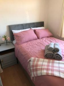 卡马森Chalet18的一间卧室配有粉红色的床和毛巾