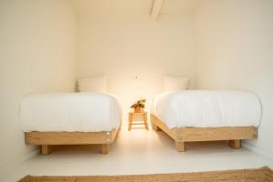 巴勒姆Nobel Houses & Lofts的客房内的两张床和白色床单
