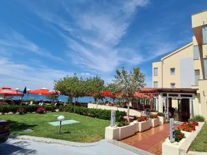 利缇纳Pension Villa Rosa的一个带遮阳伞的草坪和一座建筑的度假胜地