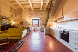 比萨Nella Torre del Poschi Penthouse with Roof Terrace的厨房以及带沙发和桌子的客厅。