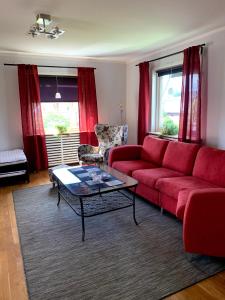 卡尔斯塔德2 rum och kök på Färjestad的客厅配有红色的沙发和桌子