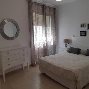 阿尔姆尼卡Portobello的一间卧室配有一张床、梳妆台和镜子