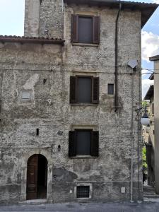 斯坎诺Alla Piazza Vecchia的一座带窗户和门的古老石头建筑