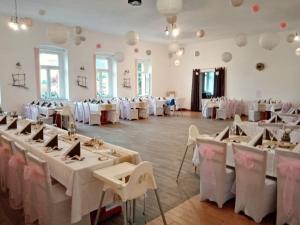 普日布拉姆Penzion Pivovar Podlesí的宴会厅配有白色的桌子和白色的椅子