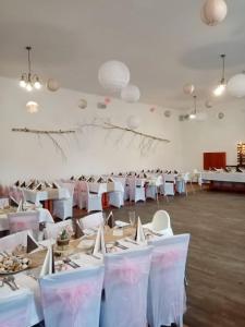 普日布拉姆Penzion Pivovar Podlesí的大房间设有白色的桌子和白色的椅子