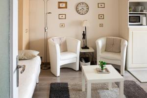 梅斯Chic En Ville的客厅配有2把白色椅子和桌子