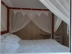 拉特里尼泰BLUE PARADISE的一间卧室配有一张带天蓬的白色床