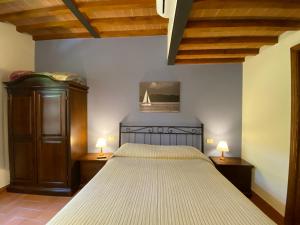 帕西亚诺特努塔巴迪亚99号酒店的一间卧室配有一张大床,桌子上放着两盏灯