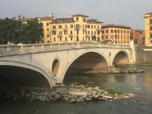 维罗纳Lady Verona Residence的一座建有建筑物的城市里河流上的桥梁