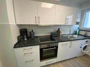 卡塞尔Apartment im Zentrum的厨房配有白色橱柜、水槽和洗碗机。