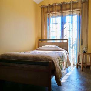 萨布盖鲁Casa dos Gémeos的一间卧室设有一张床和一个大窗户