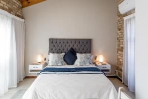 伊丽莎白港Wagtails Guest House的白色卧室,配有一张带2个床头柜的大床