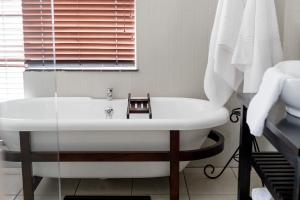 伊丽莎白港Wagtails Guest House的一间带白色浴缸和窗户的浴室