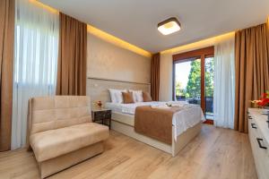 佩特罗瓦纳莫鲁Luxury Apartments Queen的卧室配有床、椅子和窗户。
