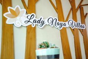 拉威海滩Lady Naya Villas - SHA Extra Plus的一张桌子旁的女柳条标语