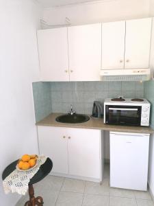 帕莱欧卡斯提撒George Michalas (Vivaria Apartments)的厨房配有白色橱柜和微波炉
