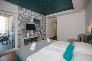德尔韦尼克Hotel Ivando的一间卧室设有一张大床和石墙