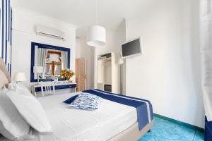 埃尔科拉诺赫库兰尼姆酒店的一间白色卧室,配有床和电视