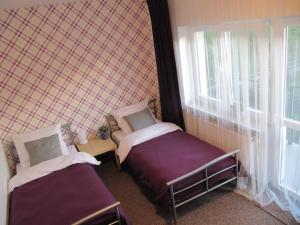 Wiśniówka MałaLeśna Villa的小房间设有两张床和窗户