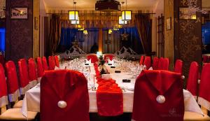 彼得罗沙尼鲁苏酒店的一张长桌子,房间带红色椅子