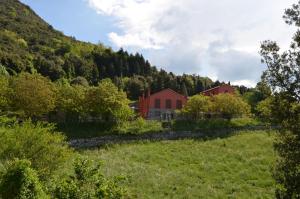 Castiglione ChiavareseAgriturismo Monte Pu'的山旁田野中的红色房子