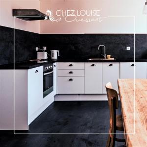 朗波普卢阿尔泽Le gite de Louise的厨房配有白色橱柜和黑色墙壁