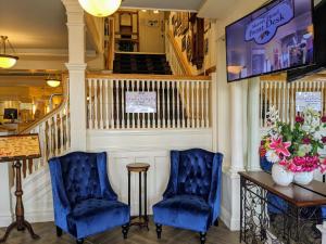 麦基诺岛默里酒店 的两个蓝色的椅子和一张桌子