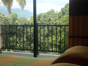 佩勒代尼耶Hanthana view的一间卧室设有享有森林美景的阳台