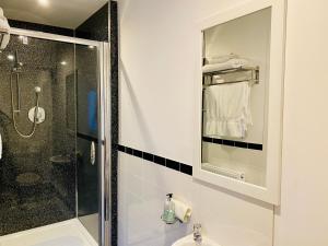 波特里Hazelmount Self-Catering Cabin的带淋浴、盥洗盆和镜子的浴室