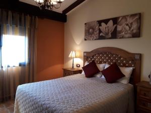 CamañasSierra Palomera的一间卧室配有一张带红色枕头的床和一扇窗户