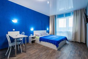 巴尔瑙尔22-HOTEL的蓝色卧室,配有床和桌子