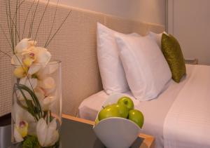 罗托鲁瓦苏迪马酒店的一间卧室配有一张床,桌子上放着一瓶水果