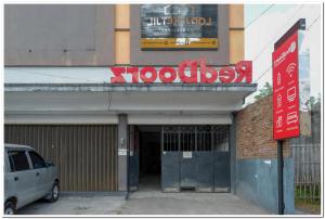 日惹RedDoorz near Jogja Expo Center 2的停在大楼前的带有标志的汽车