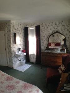 罗克波特马缨丹住宿加早餐旅馆的一间卧室配有水槽、镜子和一张床