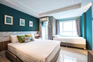 曼那拉塞尔59NW公寓式酒店的一间卧室设有两张床和蓝色的墙壁