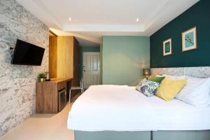 曼那拉塞尔59NW公寓式酒店的卧室配有一张白色大床和一台平面电视。