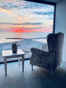 康斯坦察Maritimo Luxury ApartHotel的客厅配有椅子、桌子和窗户