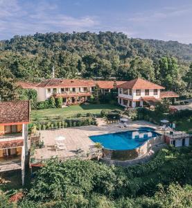 维拉杰佩特Amritara Ambatty Greens Resort的享有带游泳池的房屋的空中景致