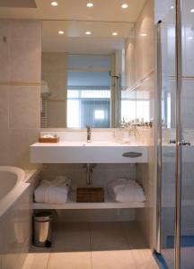 韦斯特-安-斯帕尔8号海滨酒店的一间带水槽、淋浴和镜子的浴室