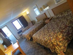 科尔尼Midtown Western Inn - Kearney的酒店客房设有两张床和一张桌子。