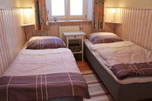 克吕茨Ferienhaus Am Linden-Brink的小型客房配有三张床和桌子。