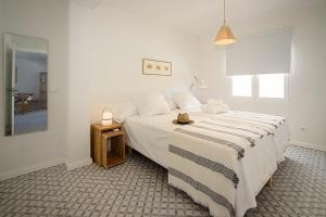 科洛尼亚圣霍尔迪BLAU Apartamento en Cala Galiota con vistas al mar的白色卧室配有一张大床和一张桌子