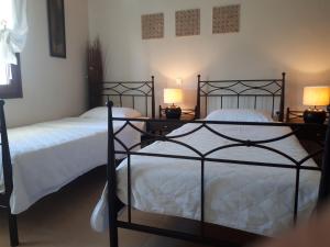 卡斯托里亚戴尔拉戈别墅精品酒店的卧室内的两张床,配有两盏灯