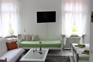 美因河畔法兰克福Hotel zur Post Schwanheim的客厅配有沙发和绿床。