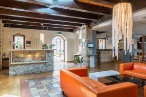 桑格罗堡Il Lavatoio Dimora Storica的客厅配有橙色家具和石制壁炉