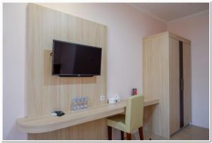 日惹RedDoorz near Gejayan 3的一间设有一张桌子的房间,墙上有一台电视机